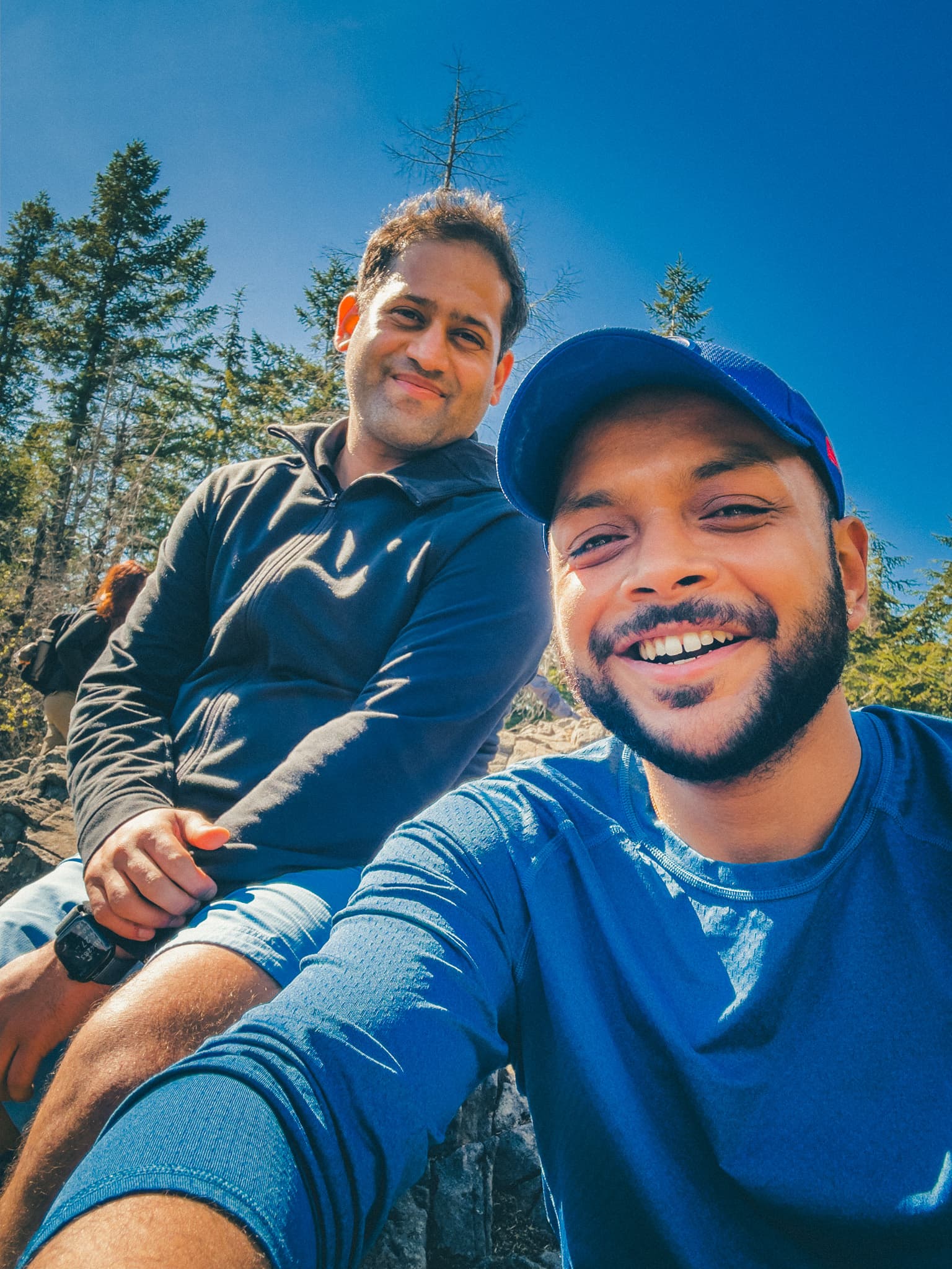Arjun and Badri at the balcony viewpoint, smiling at the summit